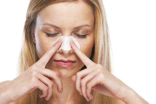 Portrait of teenage girl applying clear-up strips on nose