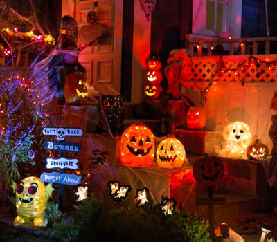 A house with Halloween pumpkins and halloween decorations at Halloween night on a city street. Trick or treat.