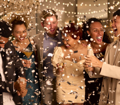 Group Of Friends Celebrating At Party Together With Drinks And Confetti